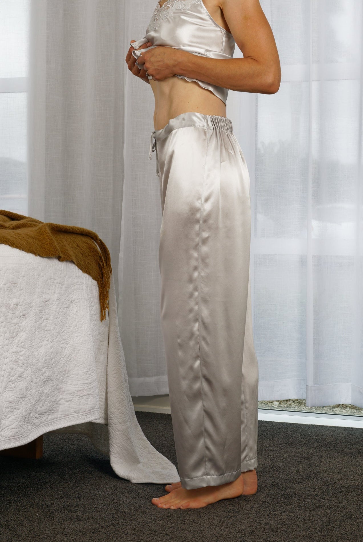 women wearing silver silk long sleepwear pants with a matching silk top
