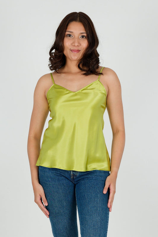 Woman wearing a green satin silk camisole and blue jeans