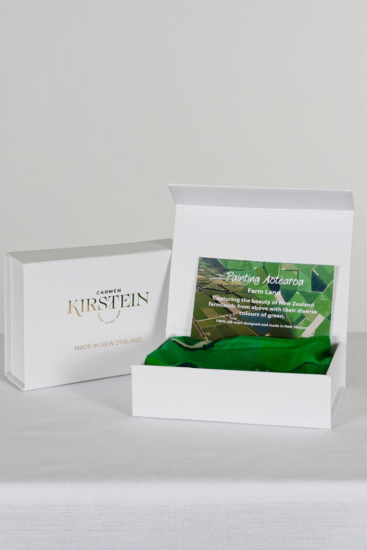 green silk satin scarf with farmland print in a white box