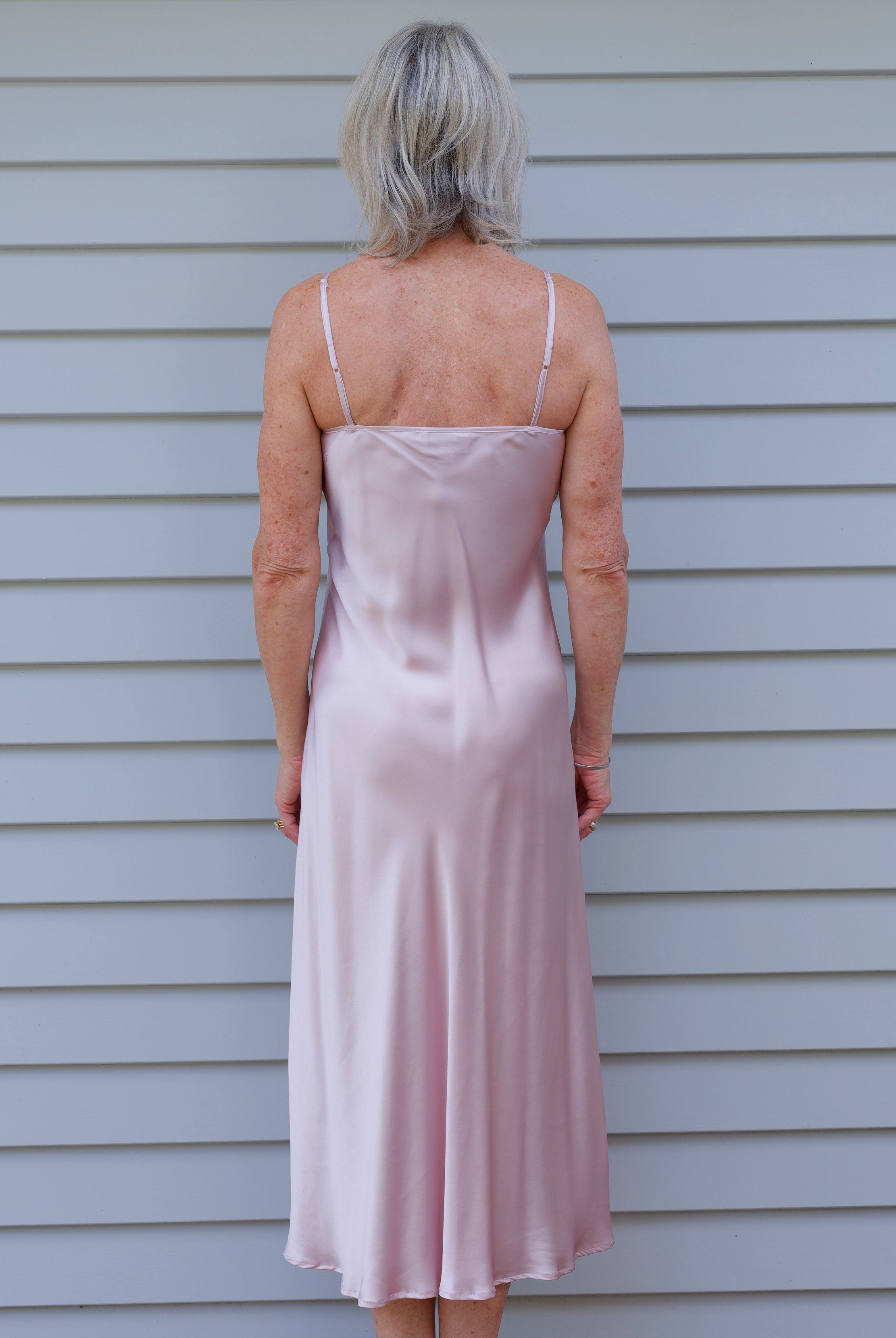 Woman in a pink silk satin nightgown