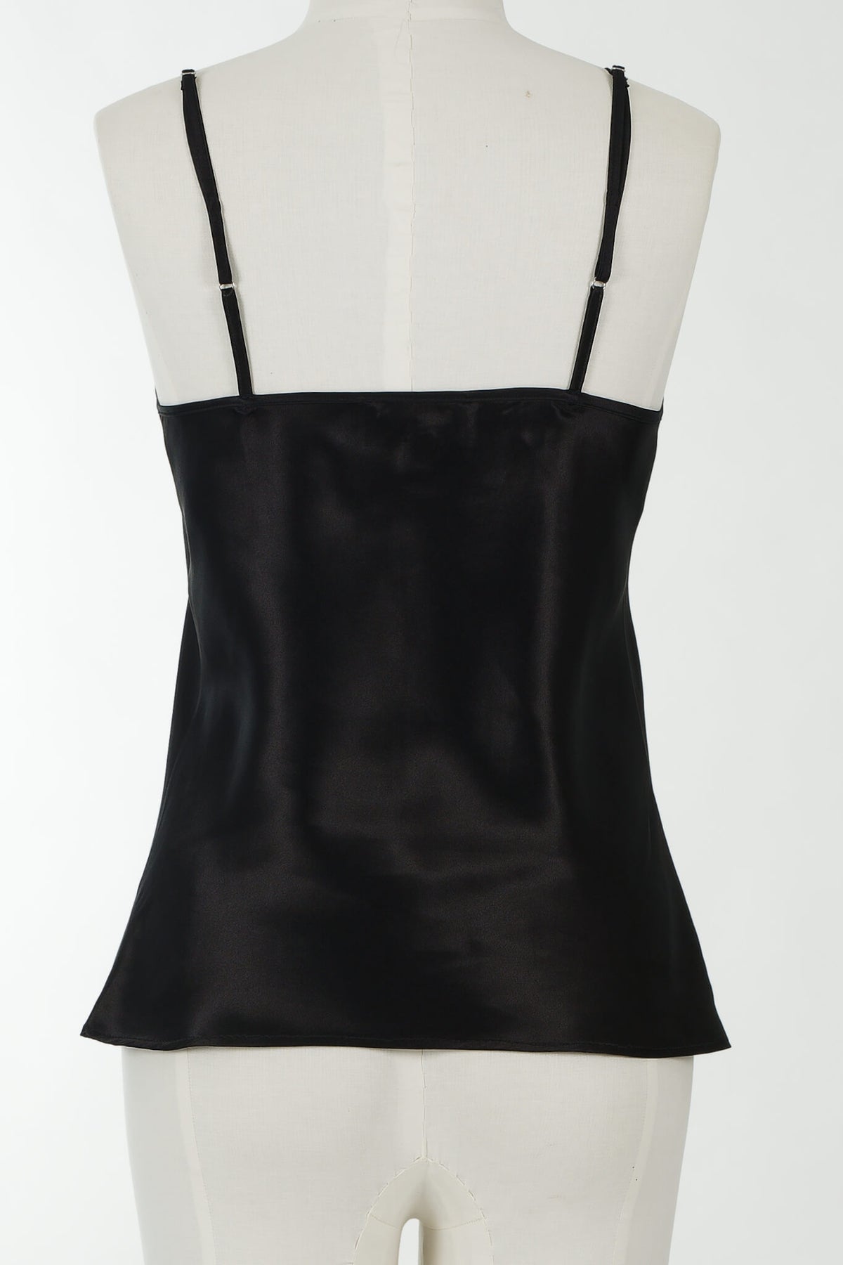 A black satin camisole top with thin shoulder straps, displayed on a white mannequin torso against a plain white background.