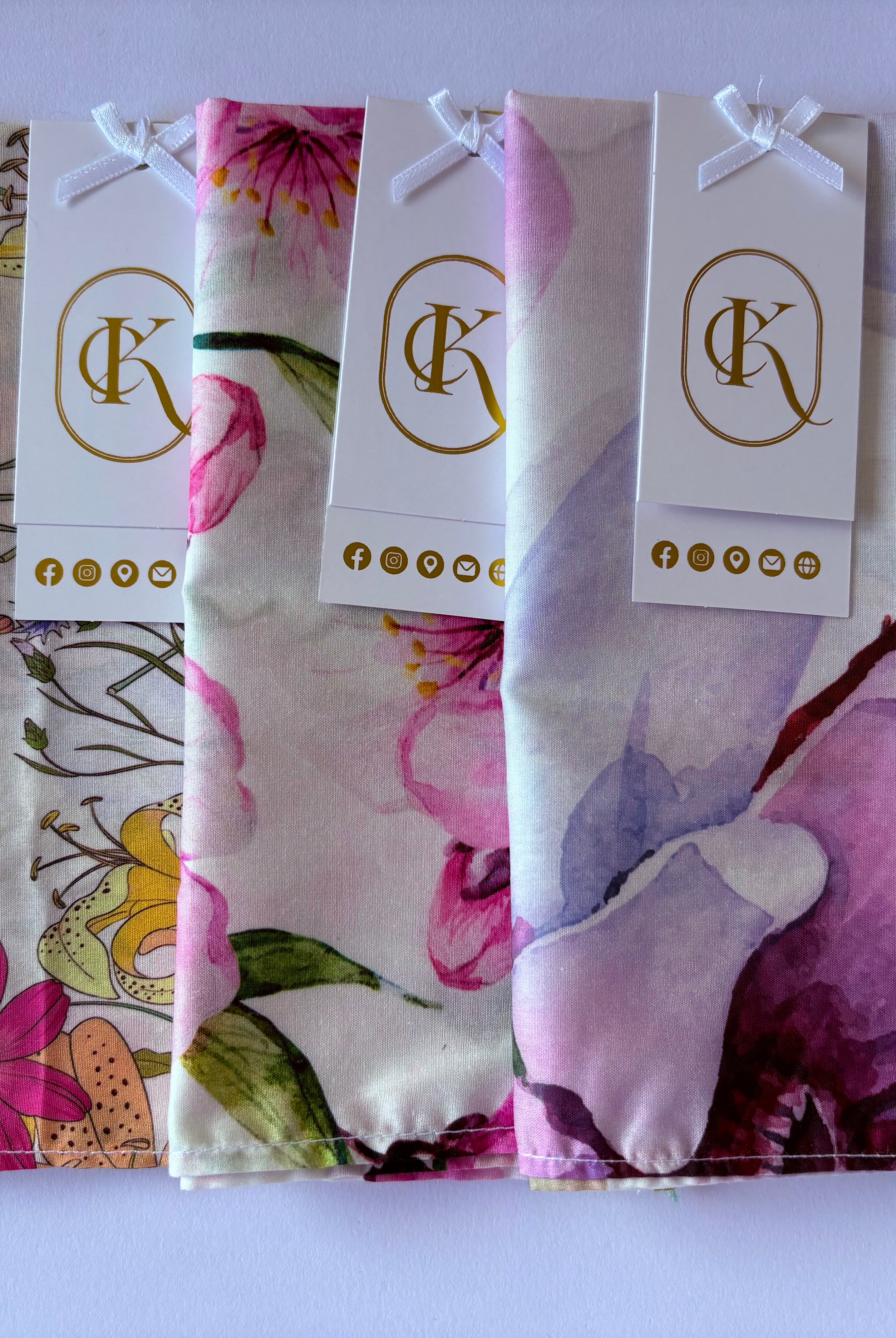 Floral-patterned hankies with branded tags on a white background