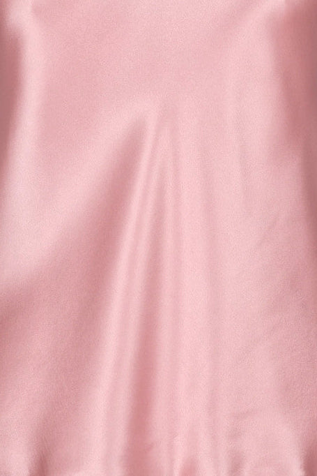 Pink silk satin camisole on a mannequin against a gray background