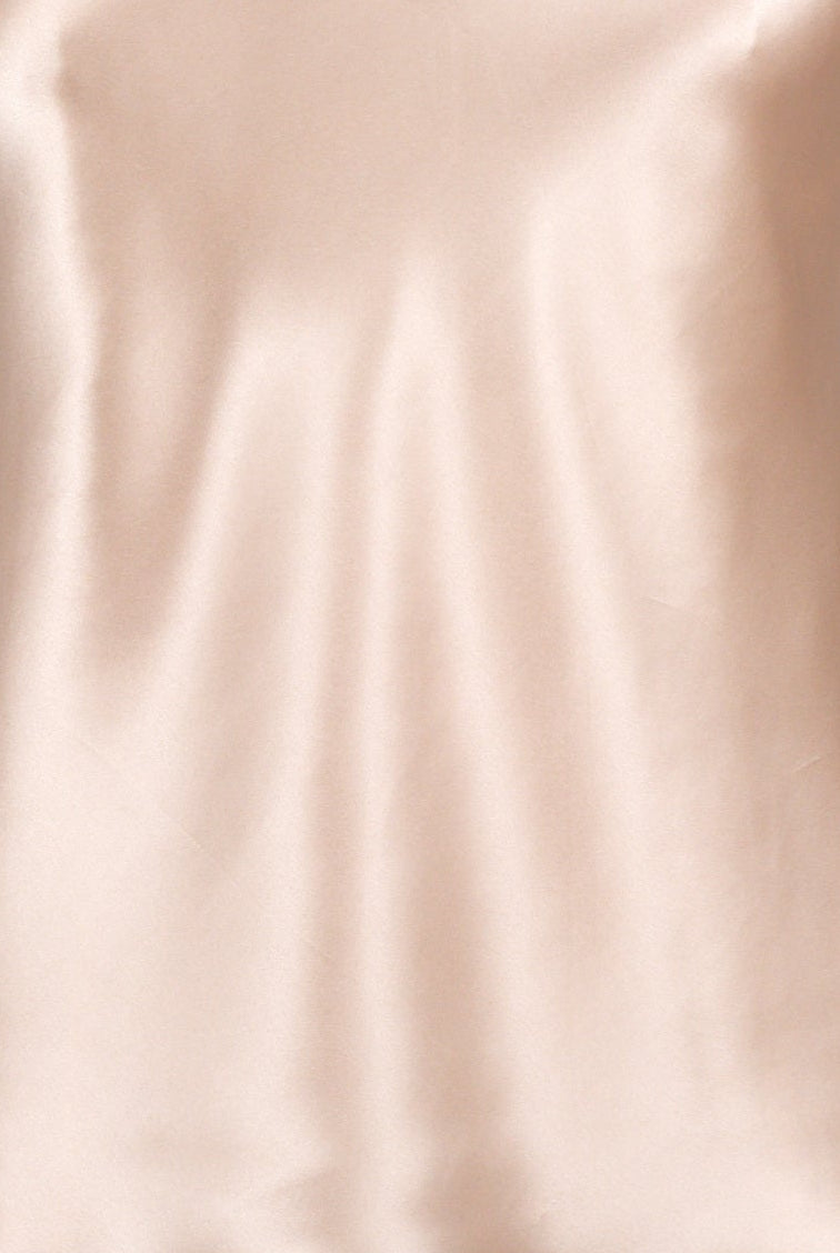 women wearing a light pink silk camisole with adjustable straps and a v neck