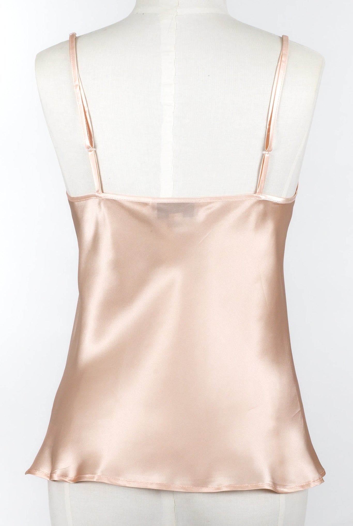 women wearing a light pink silk camisole with adjustable straps and a v neck