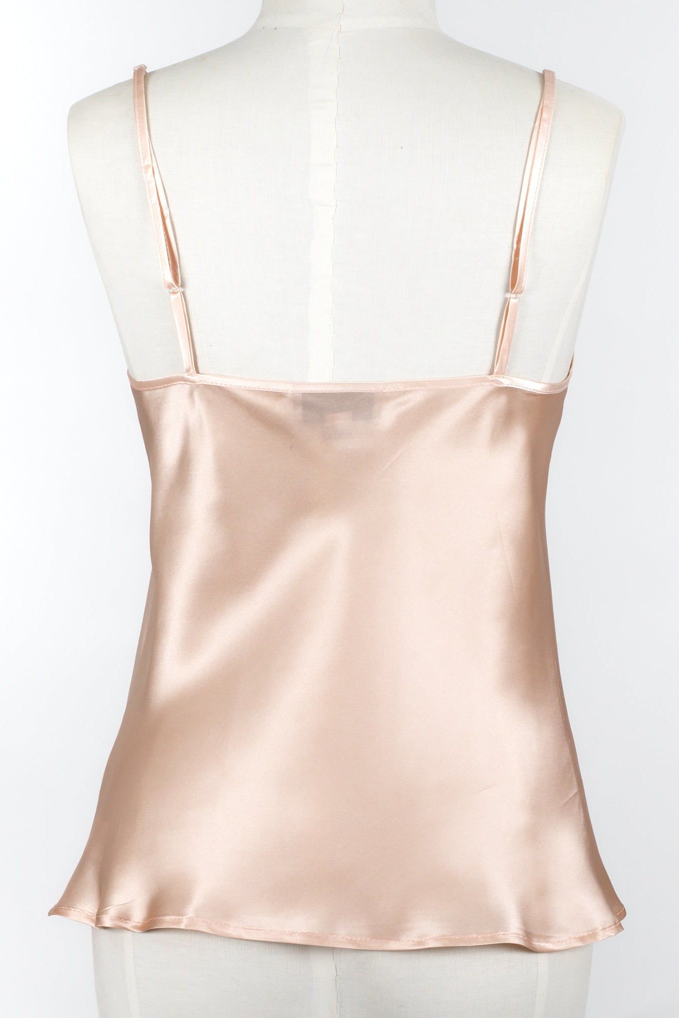 women wearing a light pink silk camisole with adjustable straps and a v neck