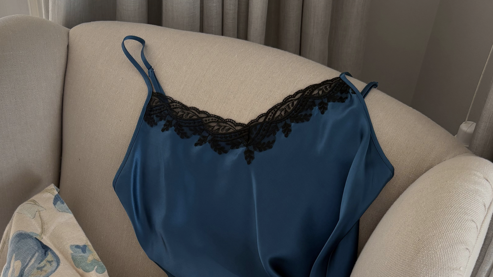 blue silk chemise with black lace trim draped on chair