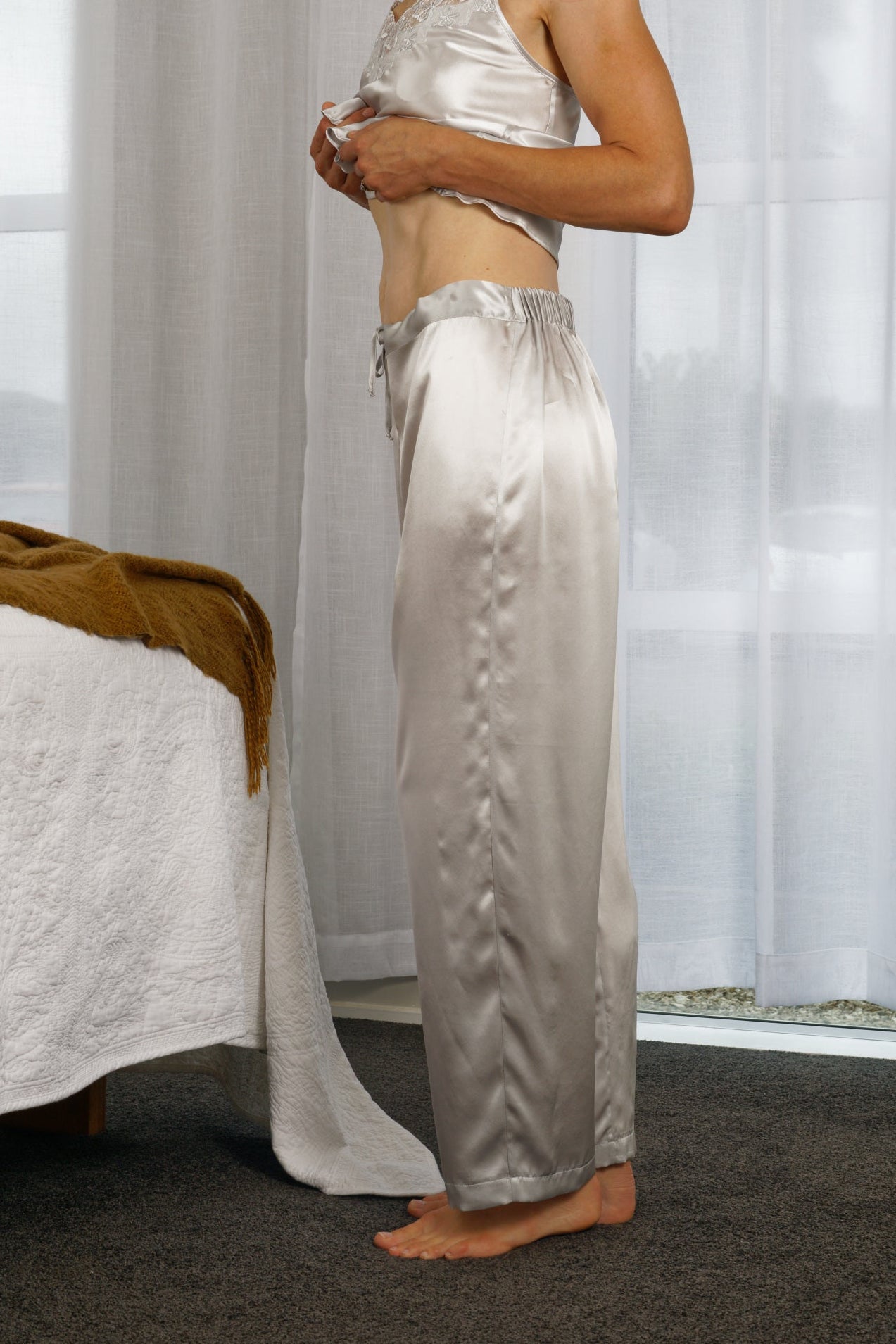 women wearing silver silk long sleepwear pants with a matching silk top