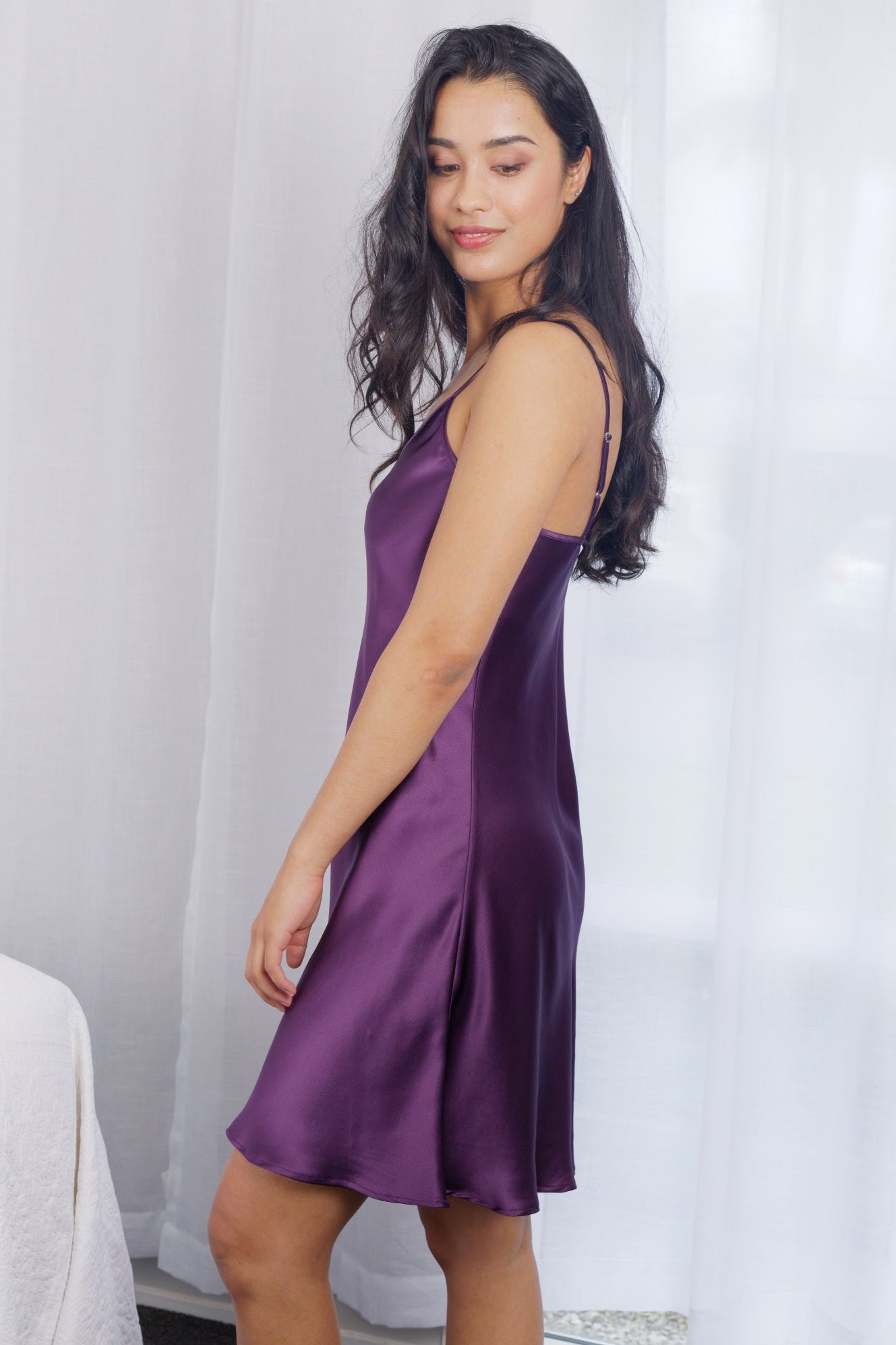 women wearing a purple silk chemise in a bedroom