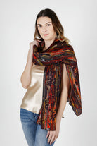 Woman wearing a red patterned silk chiffon scarf over her shoulders on a white background