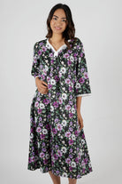 Woman wearing a floral nightie dress with white and purple flowers 