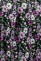 Woman wearing a floral nightie dress with white and purple flowers 