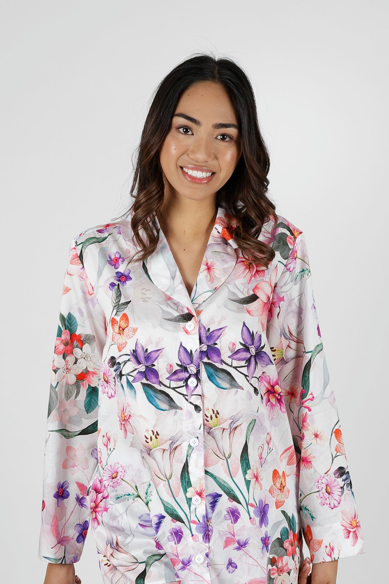 Woman wearing a floral pajama set on a gray background