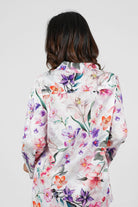 Person wearing a floral patterned shirt on a plain background