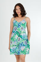 Woman wearing a floral green cotton dress nightie on a white background