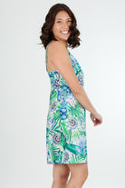 Woman wearing a floral green cotton dress nightie on a white background