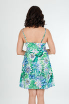Woman wearing a tropical green cotton floral nightie dress on a white background