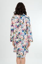 A model wearing a floral print cotton shirtdress nightie with a button-down front, collar, and full-length sleeves.