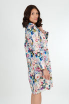 A model wearing a floral print cotton shirtdress nightie with a button-down front, collar, and full-length sleeves.