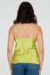 Person wearing a green silk camisole top and blue jeans on a white background
