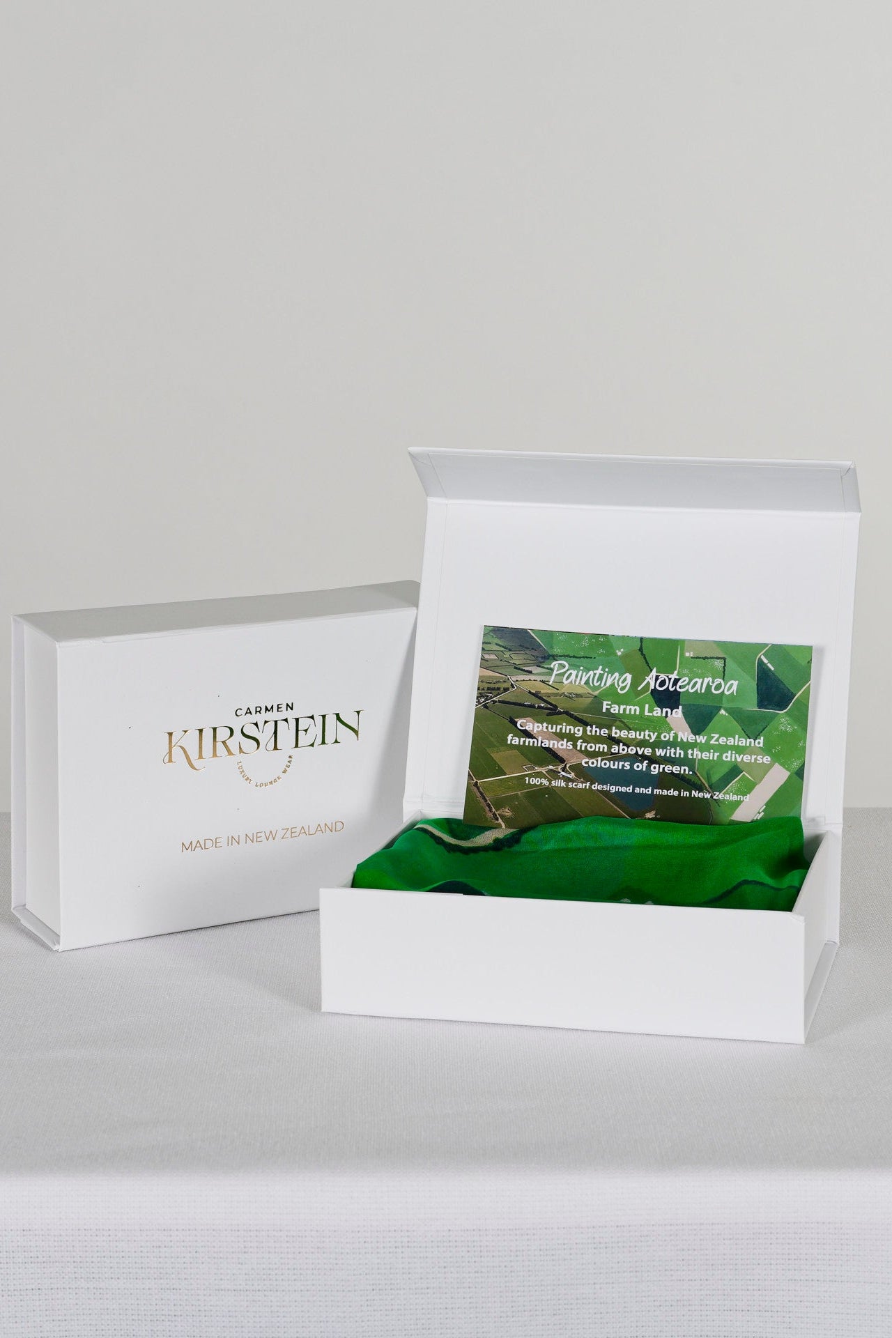 green silk satin scarf with farmland print in a white box  