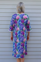 Woman wearing a floral cotton nightie with hydrangea flowers on it in blue purple and pink