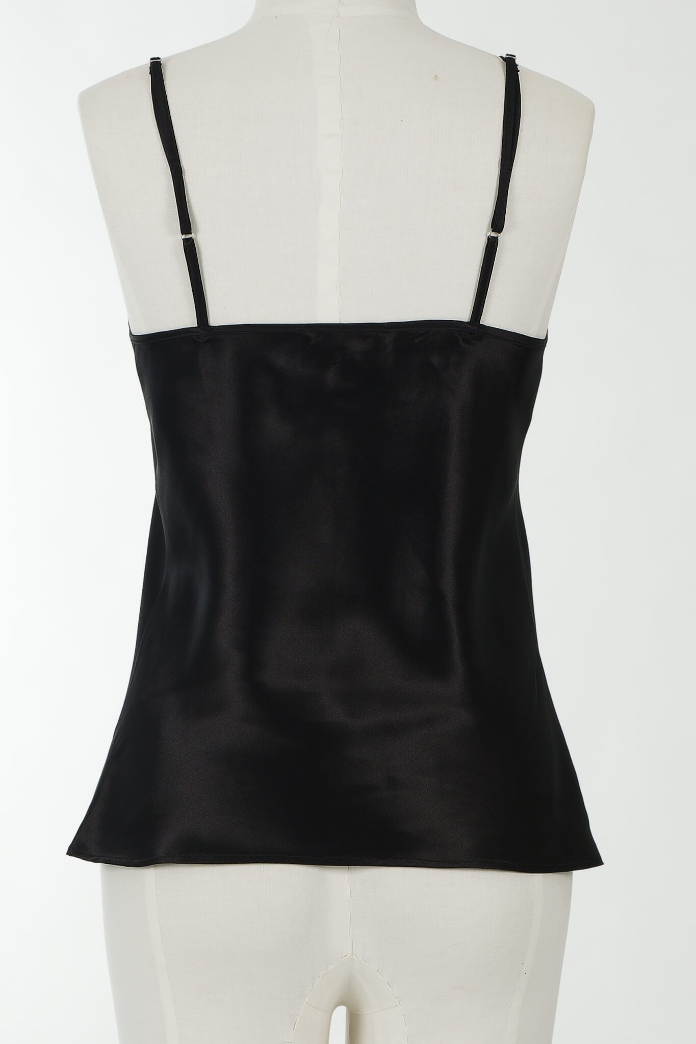 A black satin camisole top with thin shoulder straps, displayed on a white mannequin torso against a plain white background.