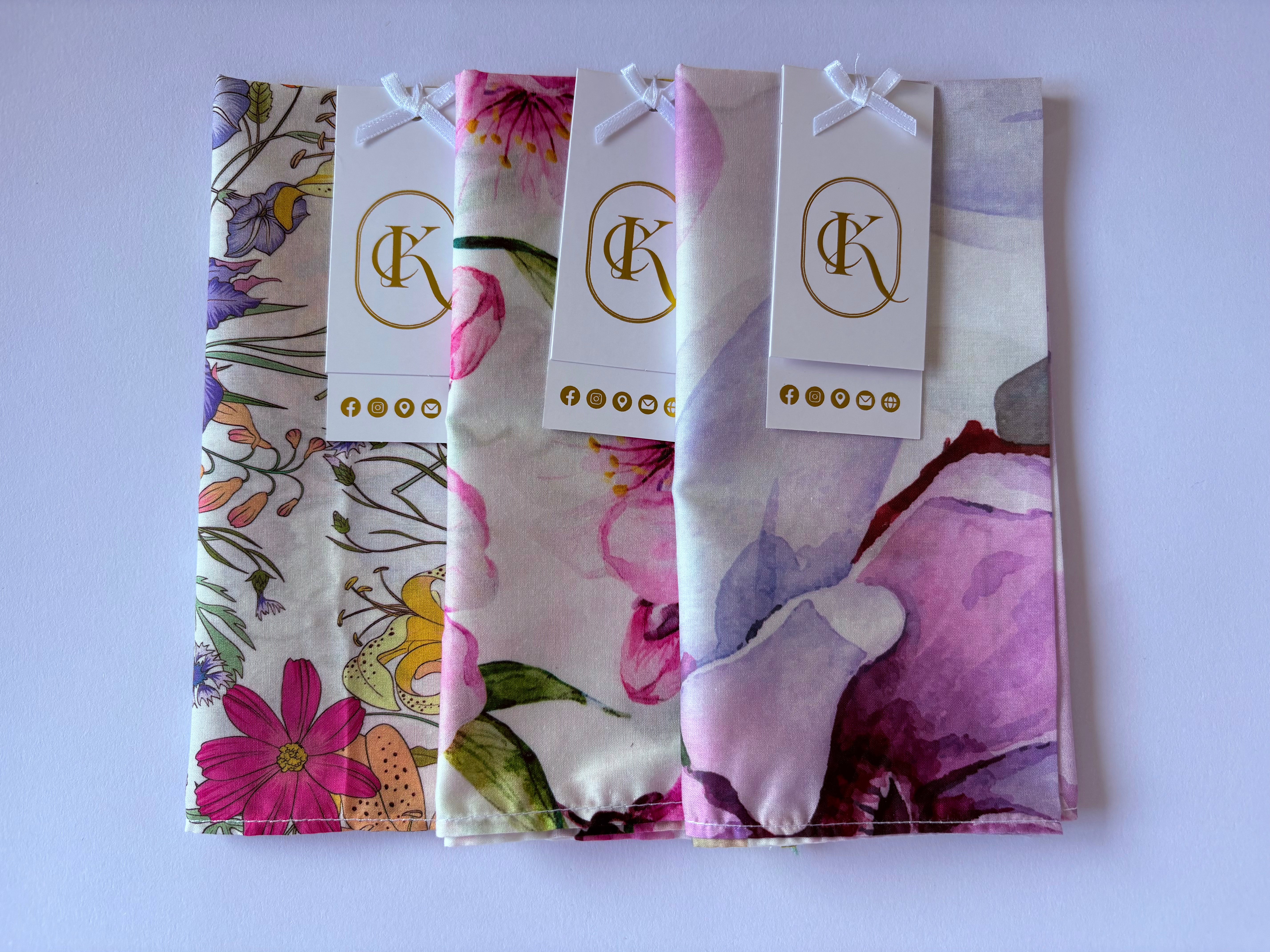 Floral-patterned hankies with branded tags on a white background