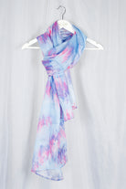 Light blue and pink silk chiffon scarf on a white hanger against a light gray background