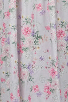 Floral patterned dress on a mannequin against a gray background