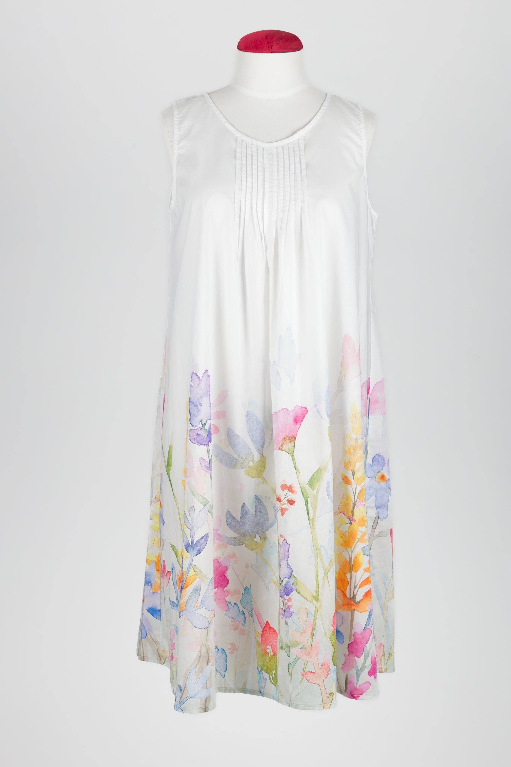 A sleeveless white night dress with a delicate pastel floral print concentrated along the lower hem, displayed on a mannequin against a light gray background.