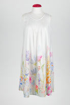 A sleeveless white night dress with a delicate pastel floral print concentrated along the lower hem, displayed on a mannequin against a light gray background.
