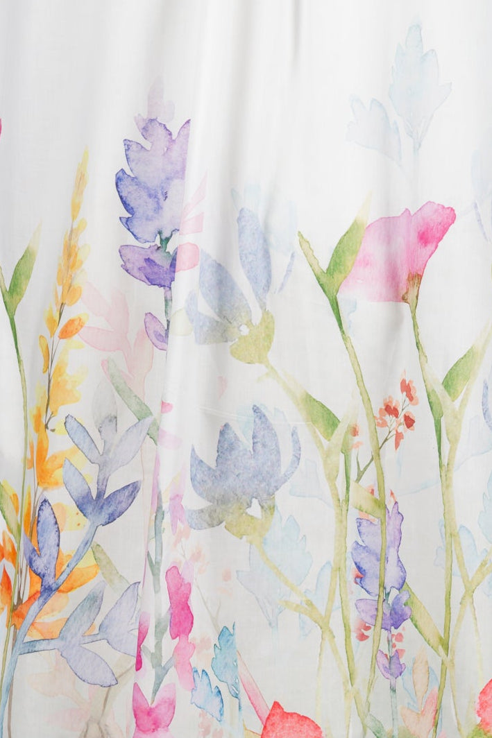 A sleeveless white night dress displayed on a mannequin against a light gray background, featuring a watercolor floral print concentrated along the lower hem.