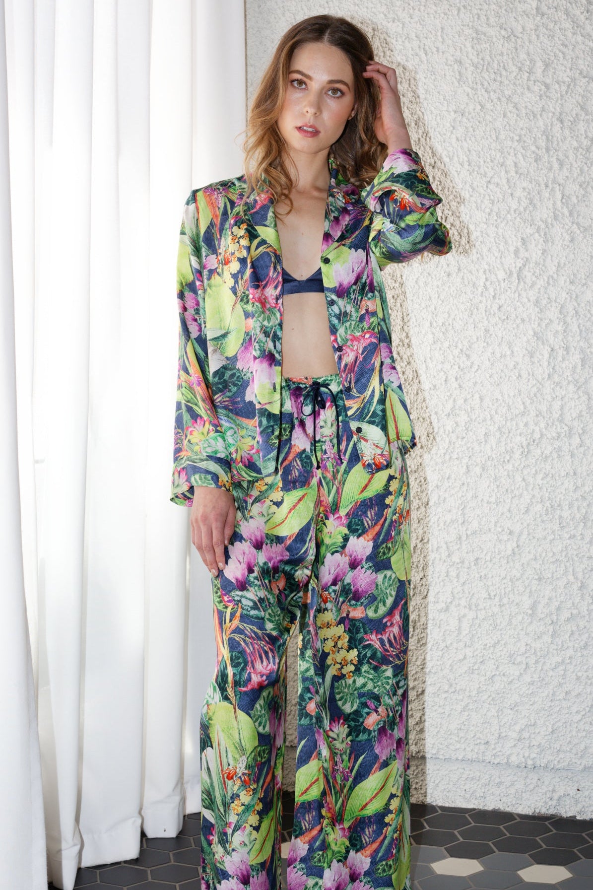 women wearing a bright green tropical print long sleeve silk shirt and matching pants