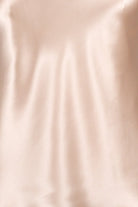 women wearing a light pink silk camisole with adjustable straps and a v neck
