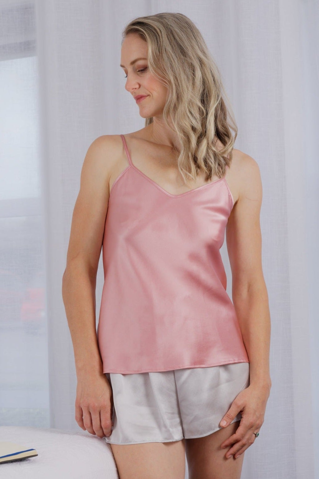 women wearing a light pink rose silk camisole 